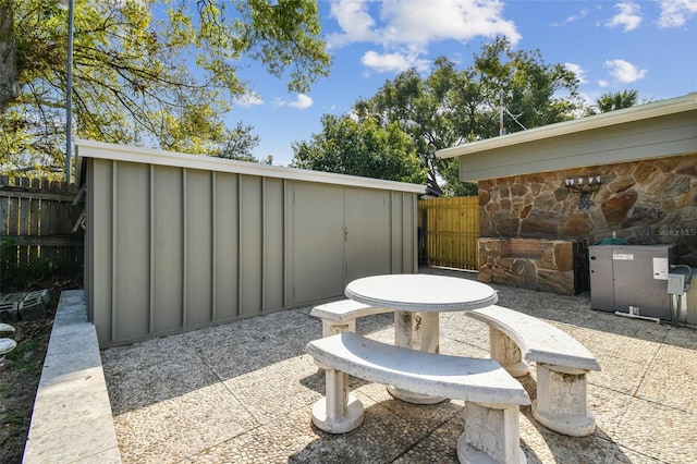 view of patio featuring an outdoor structure and fence