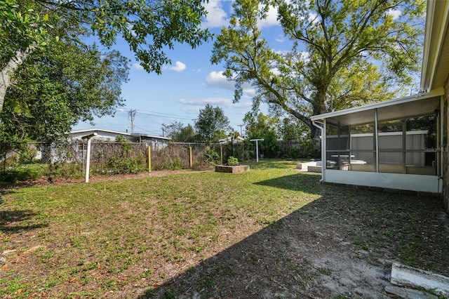 view of yard featuring a fenced backyard and a sunroom