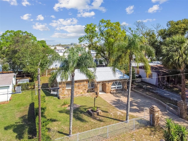 view of front of house featuring decorative driveway, stone siding, and a front lawn