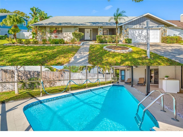 view of swimming pool with fence, a lawn, and a fenced in pool