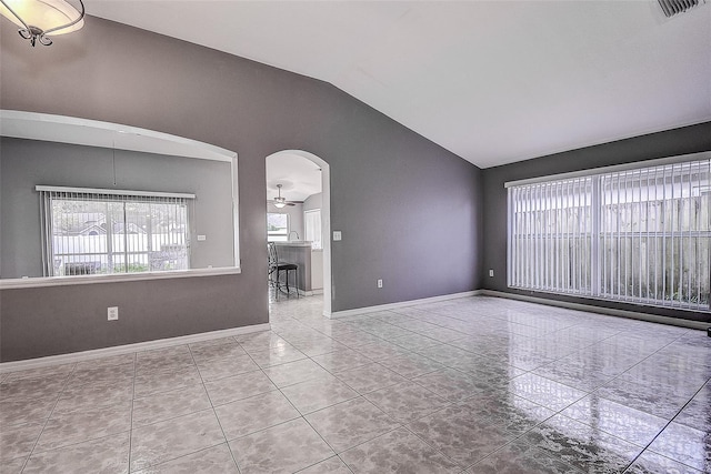 unfurnished living room featuring arched walkways, lofted ceiling, visible vents, baseboards, and tile patterned floors