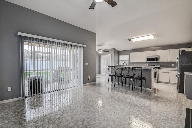 kitchen with visible vents, appliances with stainless steel finishes, a kitchen breakfast bar, light countertops, and white cabinetry