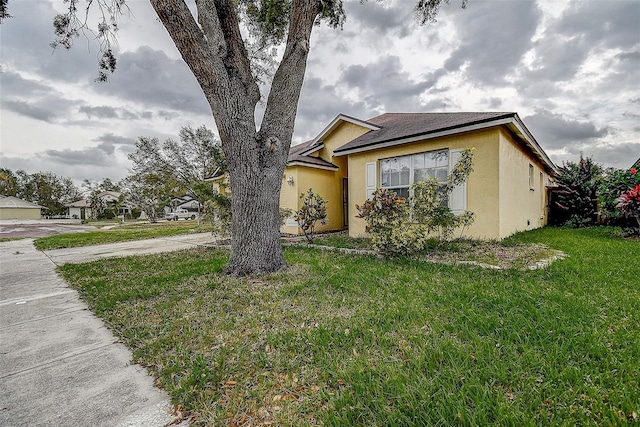 view of front facade with a front lawn and stucco siding