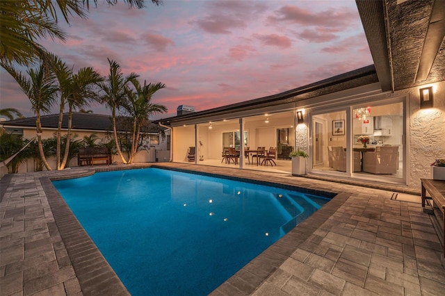 pool with a patio and outdoor dining area