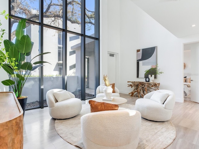 living room with a healthy amount of sunlight, a towering ceiling, and baseboards