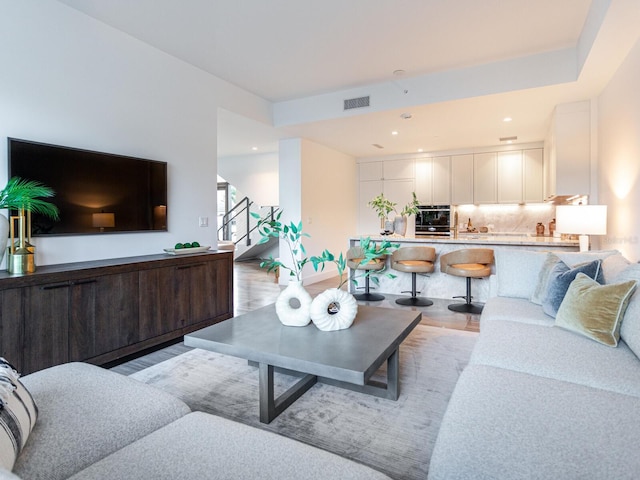 living room with light wood finished floors, stairway, visible vents, and recessed lighting