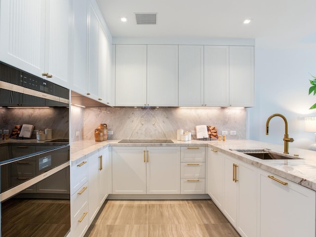 kitchen with white cabinetry, a sink, and black electric stovetop