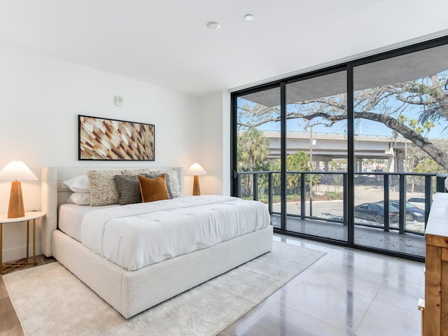 bedroom featuring expansive windows and access to exterior