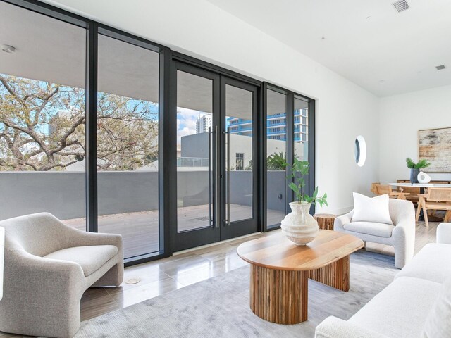 living area featuring floor to ceiling windows and visible vents