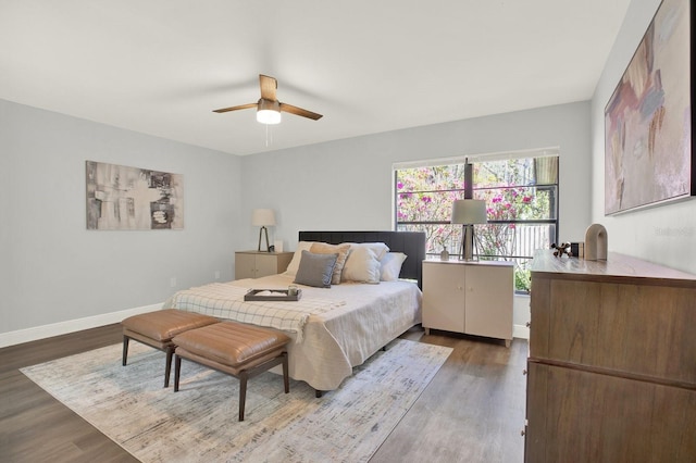 bedroom featuring a ceiling fan, baseboards, and wood finished floors