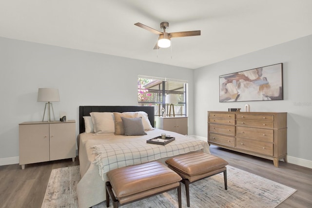 bedroom featuring ceiling fan, light wood finished floors, and baseboards