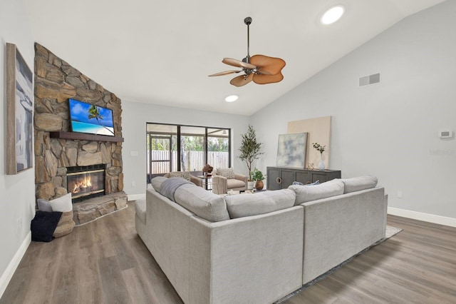 living room with a fireplace, visible vents, wood finished floors, high vaulted ceiling, and baseboards