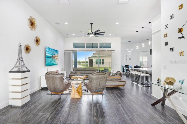 living room with recessed lighting, a towering ceiling, ceiling fan, wood finished floors, and baseboards