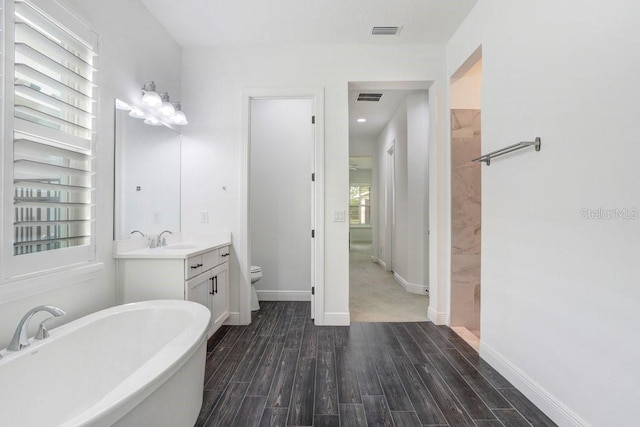 full bath featuring a soaking tub, visible vents, toilet, wood tiled floor, and vanity