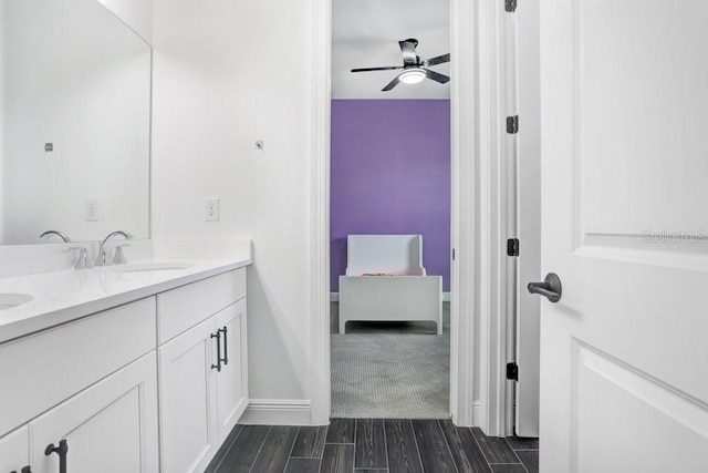 ensuite bathroom featuring double vanity, a ceiling fan, ensuite bathroom, wood finish floors, and a sink