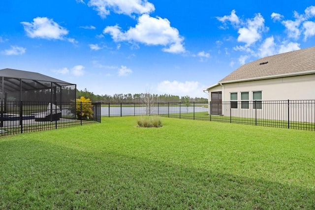 view of yard with glass enclosure and fence