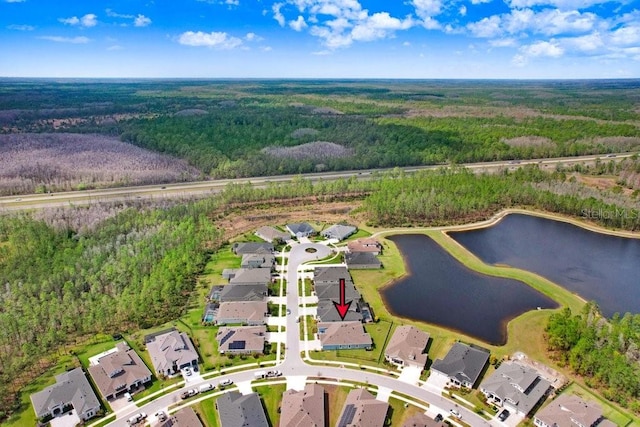 aerial view with a forest view, a water view, and a residential view