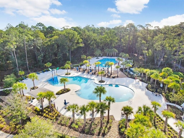 pool featuring a patio area and a view of trees