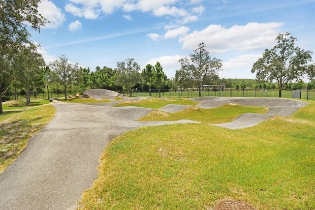 view of community with fence and a lawn