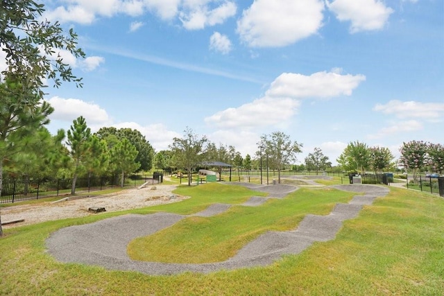 view of home's community with a yard and fence