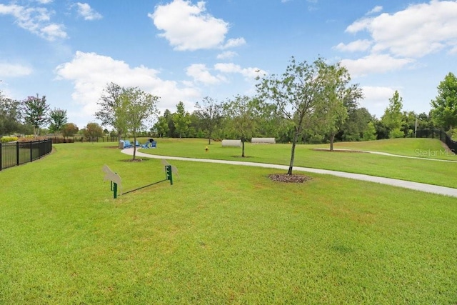 surrounding community featuring fence and a lawn