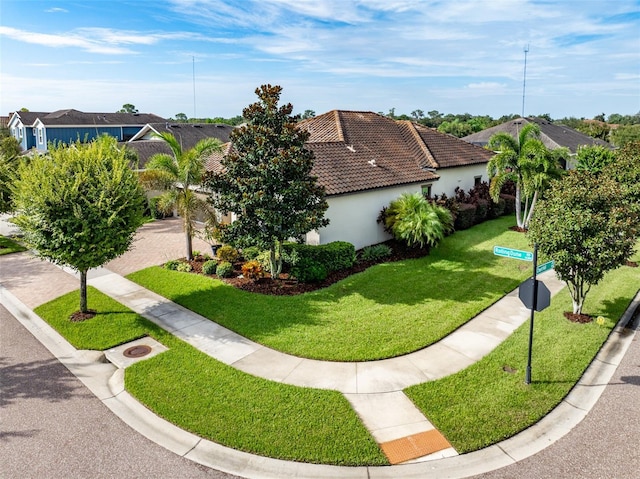 exterior space with a yard, a tile roof, and stucco siding