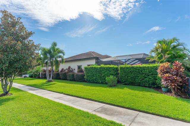 exterior space with a tile roof, a lawn, and stucco siding