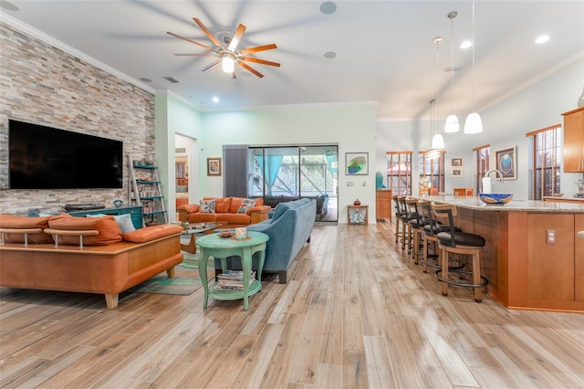 living room featuring visible vents, ornamental molding, light wood-type flooring, and a ceiling fan