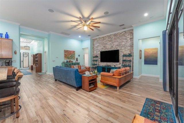 living room with baseboards, visible vents, crown molding, and light wood finished floors