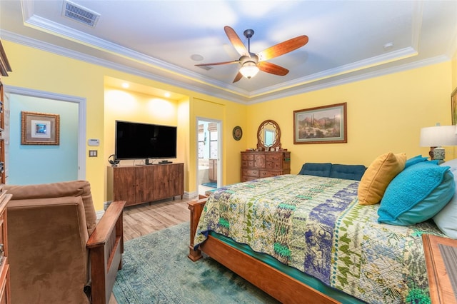 bedroom featuring crown molding, visible vents, ensuite bathroom, ceiling fan, and wood finished floors