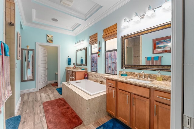 full bathroom featuring two vanities, wood finished floors, a sink, crown molding, and a bath