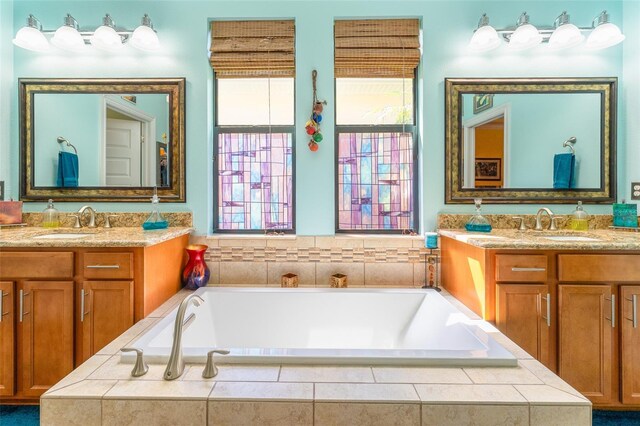 bathroom featuring two vanities, a healthy amount of sunlight, and a sink