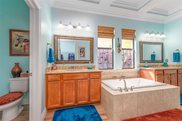 bathroom with a garden tub, ornamental molding, a sink, and toilet