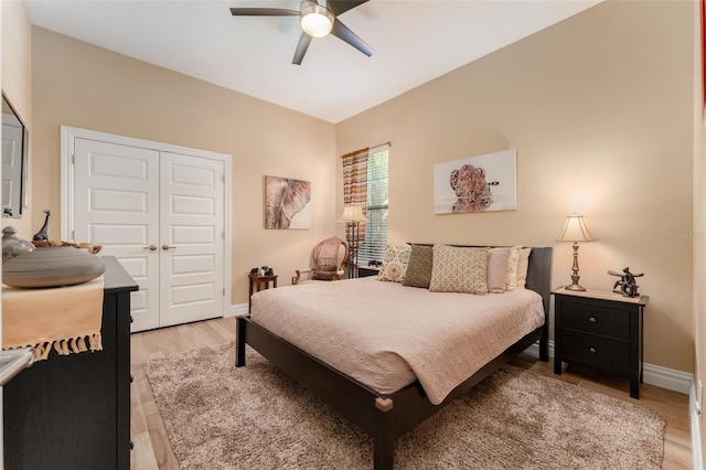 bedroom with a ceiling fan, a closet, light wood-style flooring, and baseboards