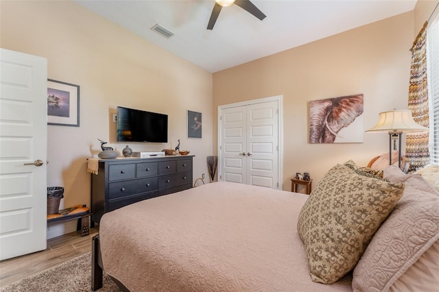 bedroom featuring ceiling fan, a closet, wood finished floors, and visible vents