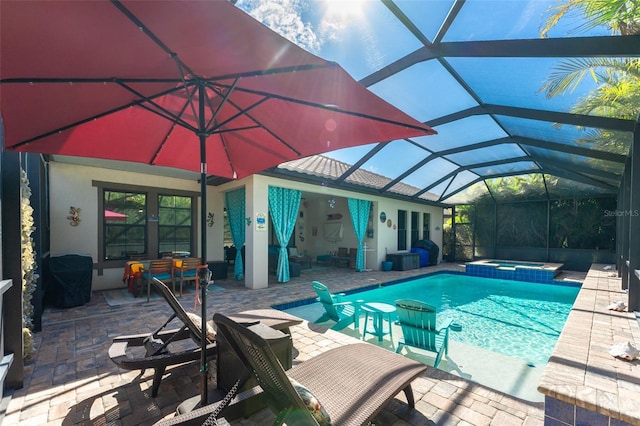 view of swimming pool with a patio area, a pool with connected hot tub, and glass enclosure