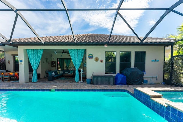 back of house with a lanai, an outdoor hangout area, a pool with connected hot tub, a tiled roof, and a patio area