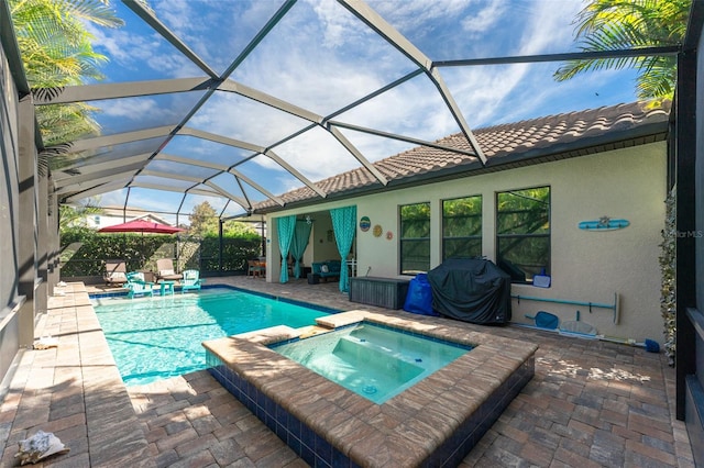 view of pool with a patio, grilling area, a pool with connected hot tub, and glass enclosure