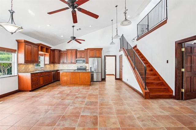 kitchen featuring visible vents, stainless steel appliances, decorative light fixtures, tasteful backsplash, and a center island