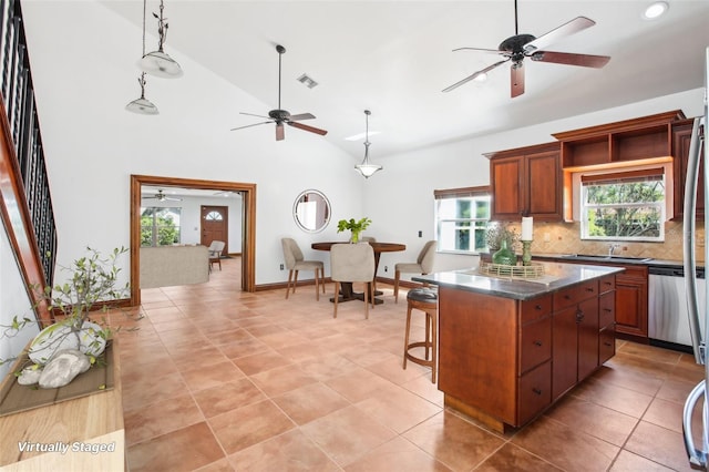 kitchen featuring visible vents, backsplash, a kitchen island, dark countertops, and dishwasher