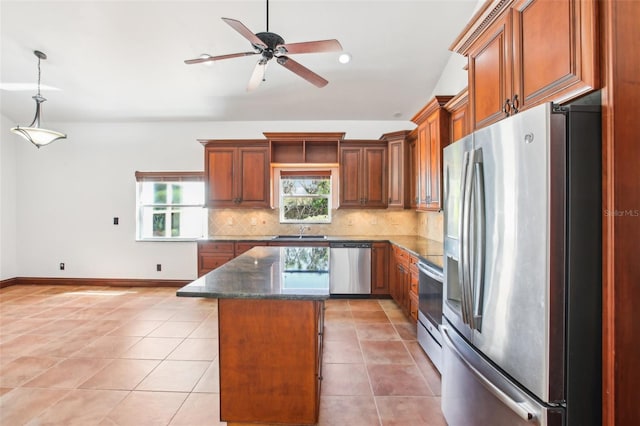 kitchen featuring brown cabinets, a sink, a kitchen island, tasteful backsplash, and appliances with stainless steel finishes