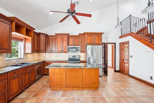 kitchen featuring visible vents, a sink, stainless steel appliances, tasteful backsplash, and a center island