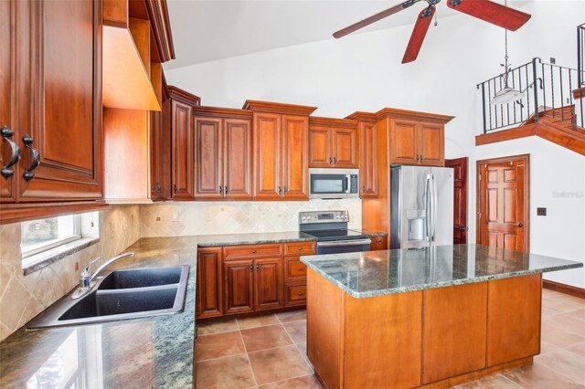 kitchen with a sink, backsplash, a center island, stainless steel appliances, and light tile patterned floors