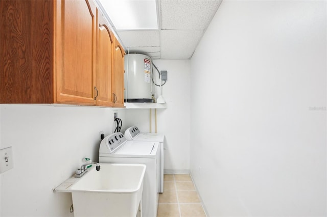 clothes washing area featuring washer and clothes dryer, a sink, water heater, cabinet space, and light tile patterned floors