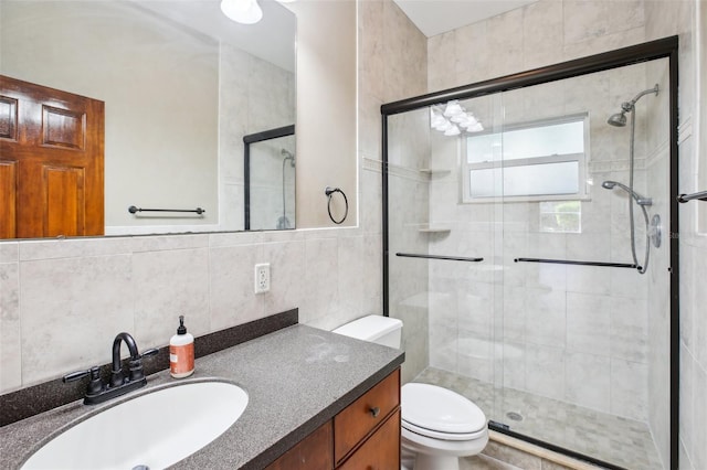 full bathroom featuring vanity, tile walls, toilet, and a stall shower