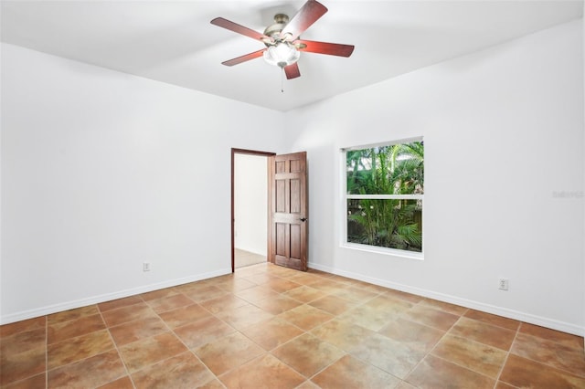 empty room featuring baseboards, light tile patterned flooring, and a ceiling fan