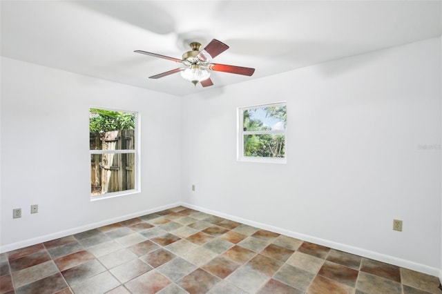 unfurnished room with baseboards, plenty of natural light, and a ceiling fan