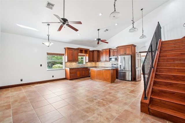 kitchen with visible vents, light tile patterned flooring, decorative backsplash, appliances with stainless steel finishes, and a center island