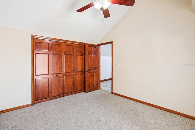 unfurnished bedroom featuring baseboards, light carpet, a ceiling fan, and vaulted ceiling