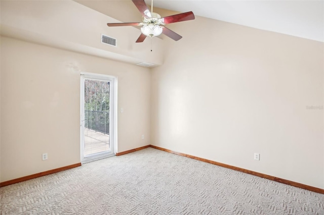 empty room with visible vents, lofted ceiling, a ceiling fan, carpet flooring, and baseboards